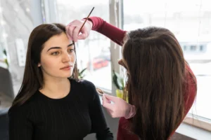 female master put eyebrow paint with brush make up procedure